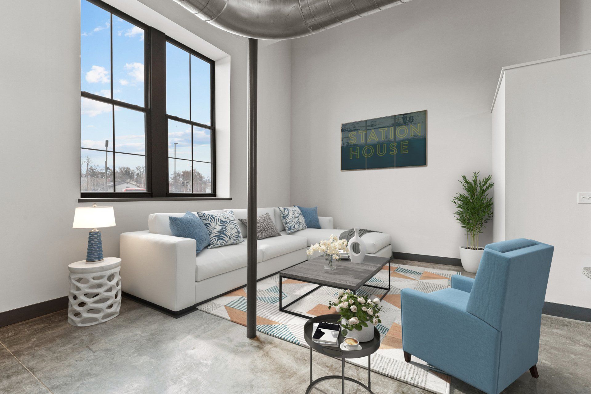 Modern living room with white sofa, blue chair, glass coffee table, large windows, and a potted plant