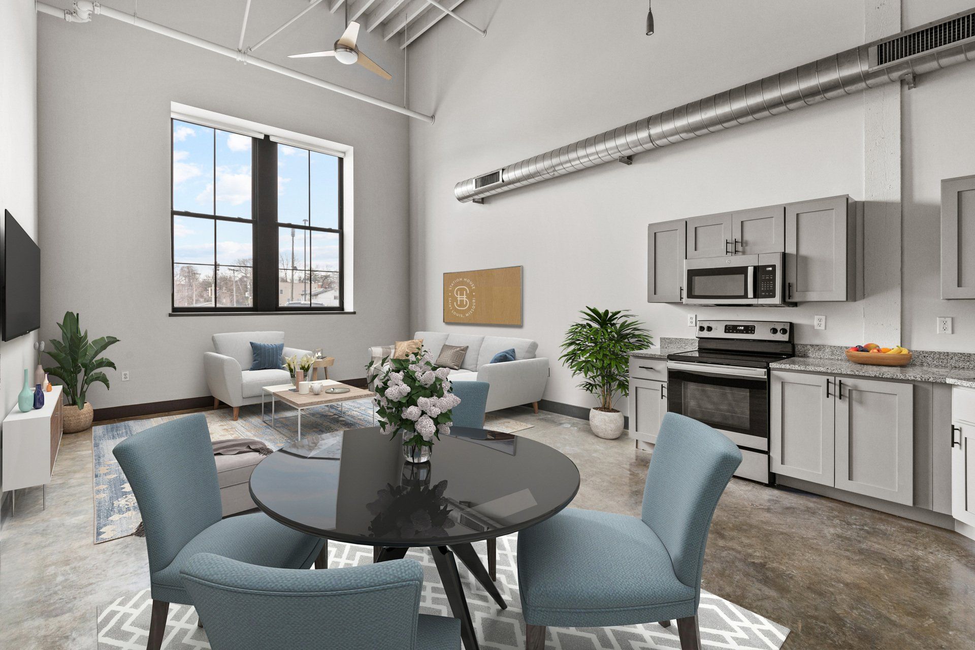 Bright modern apartment with open kitchen, dining table, and living area with blue chairs and large window.