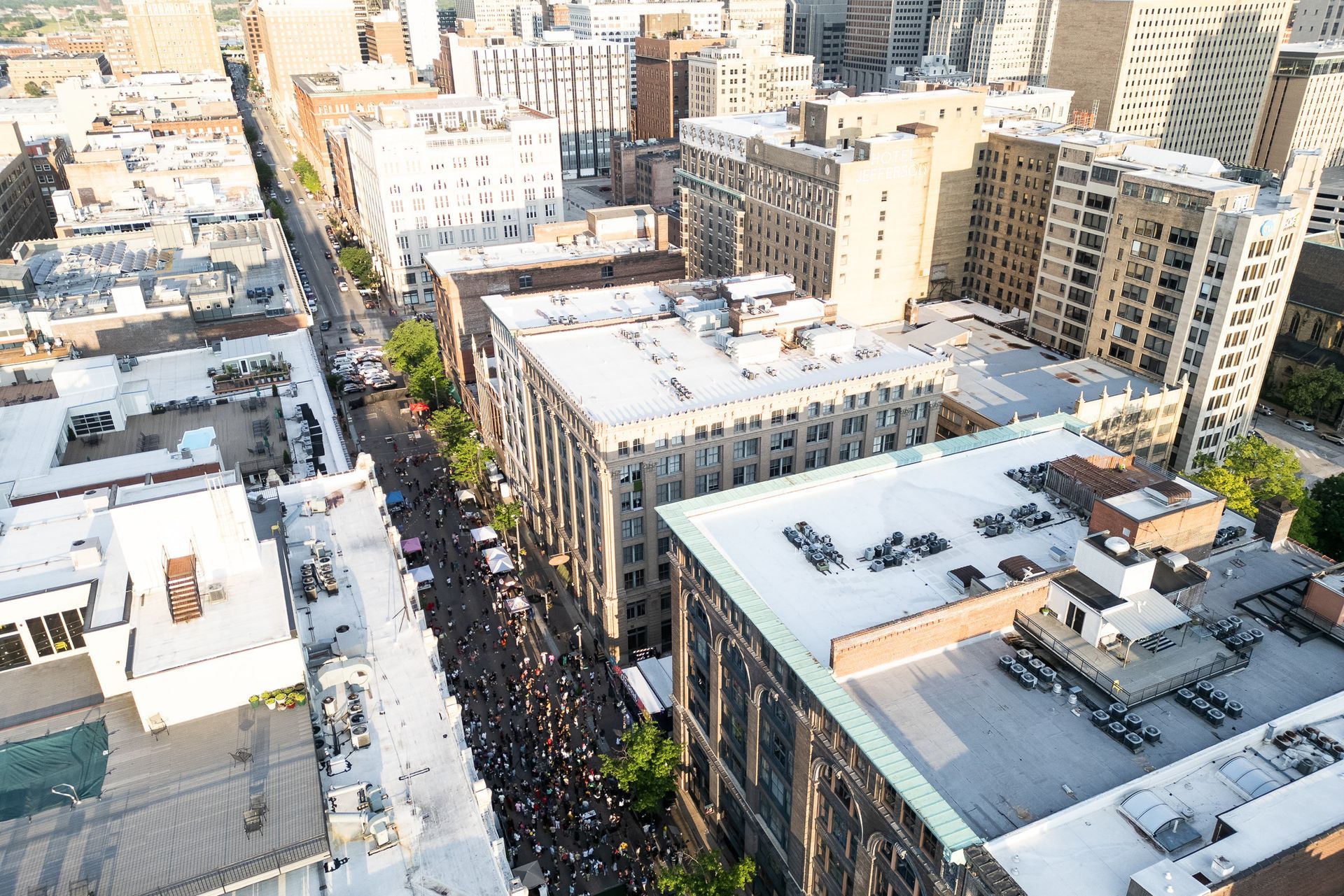 Aerial view of a busy city street lined with tall apartment buildings and rooftops.