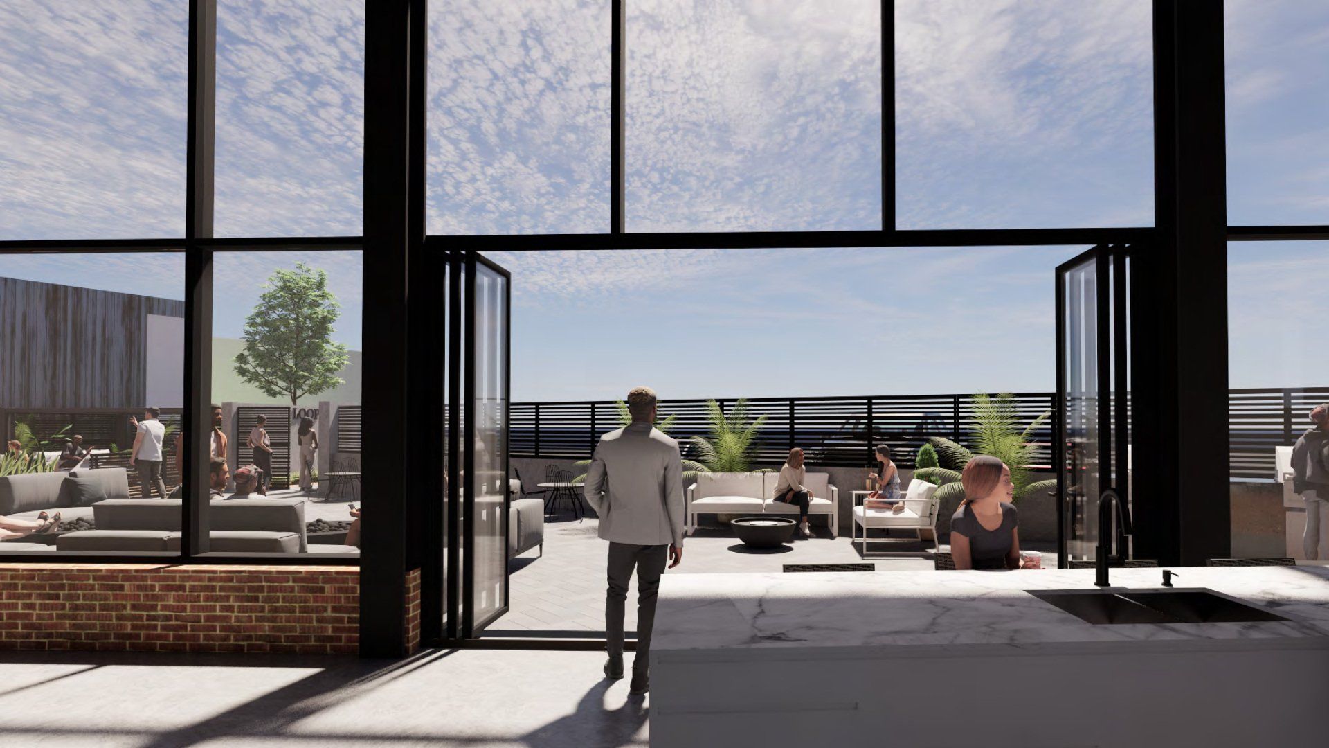 Modern patio lounge with a person walking toward outdoor seating under large glass doors, bright daylight