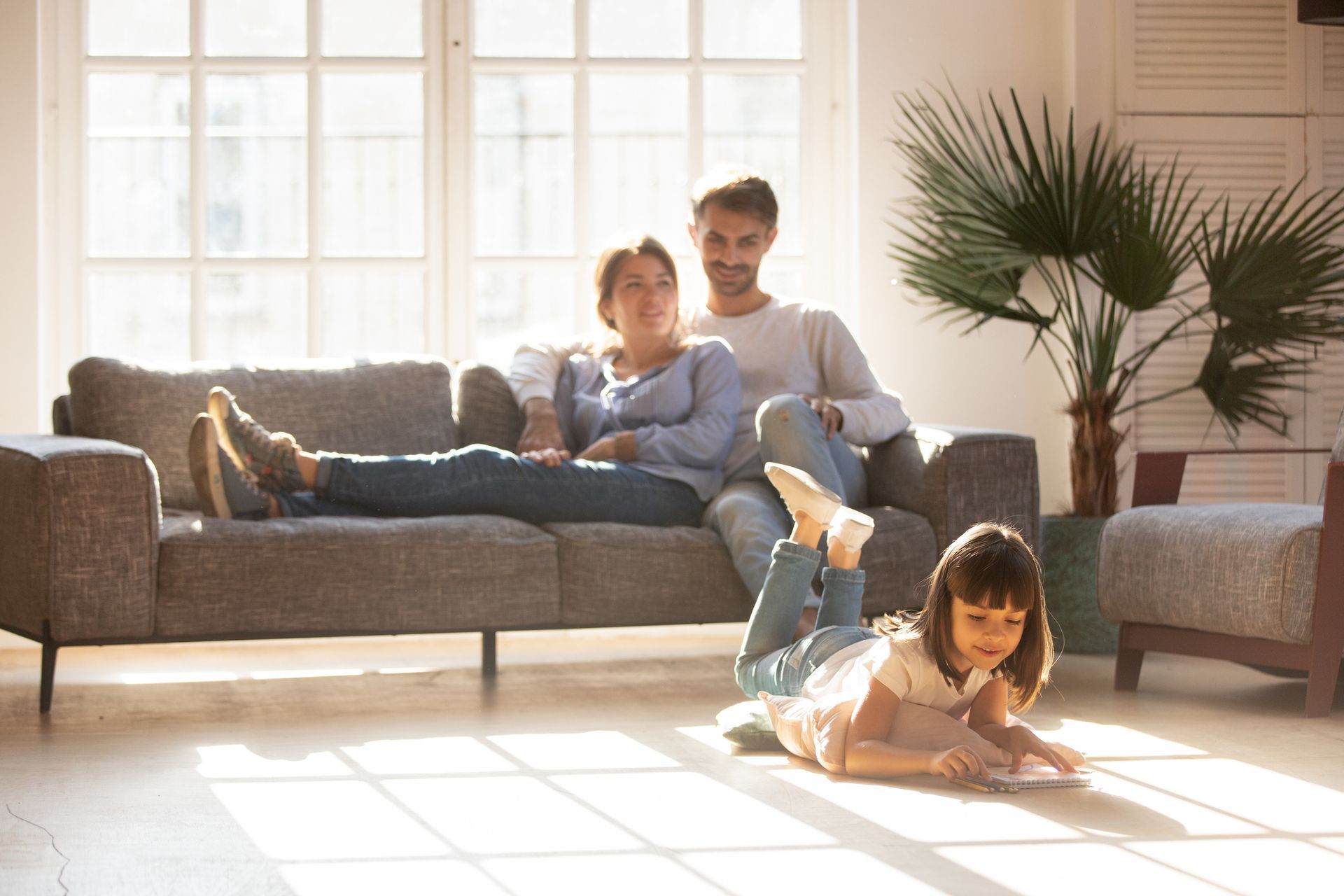 Happy Parents Relaxing On Couch - Vinton, IA - Edwards Plumbing Heating & Air Conditioning