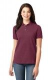 A woman is wearing a maroon polo shirt and jeans.