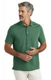 A man is wearing a green polo shirt and white pants.