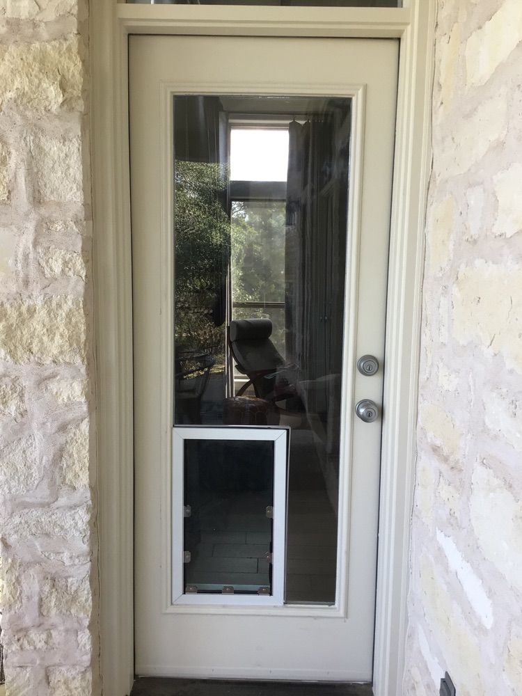 A white door with a dog door attached to it.