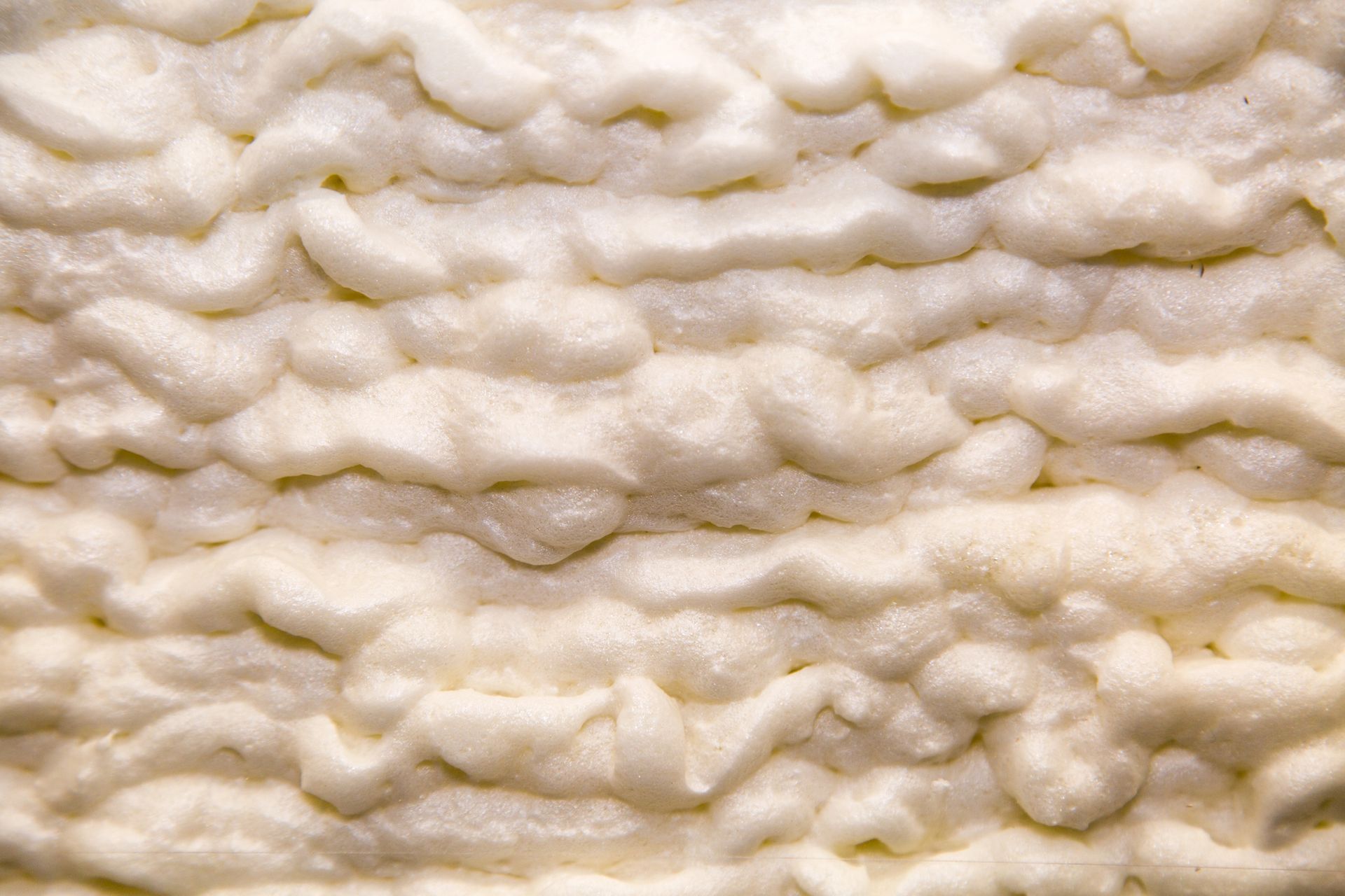 Detailed view of cured spray foam insulation applied in a Sheridan, WY crawl space.