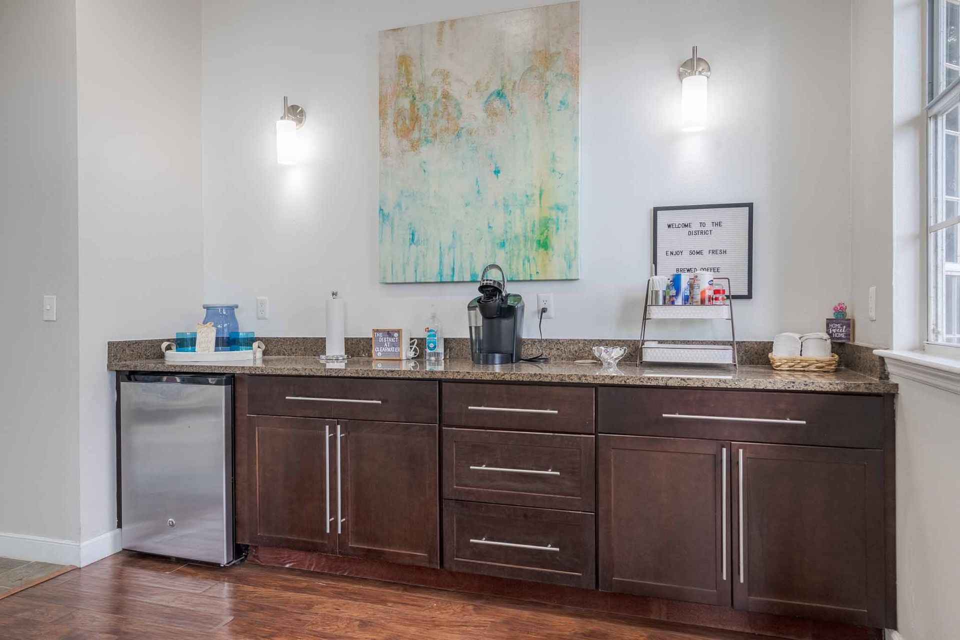 Coffee station with espresso machine, cabinets, artwork, and refrigerator. Experience the comfort of our Clearwater, FL apartments with a guided tour.