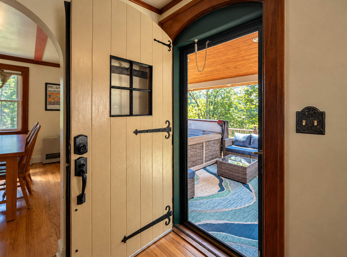 Open doorway leading from Red Fox Townhouse to a covered outdoor deck with a private hot tub and seating area.