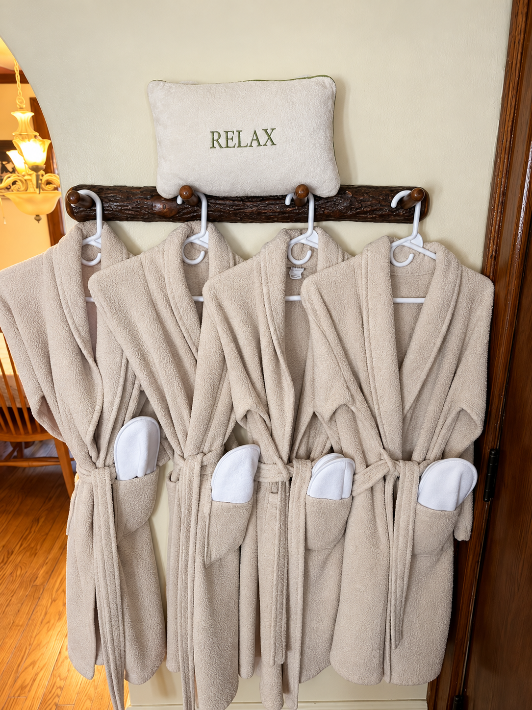 Soft guest bathrobes hanging beneath a Relax pillow at Red Fox Townhouse, ready for a cozy Catskills getaway.