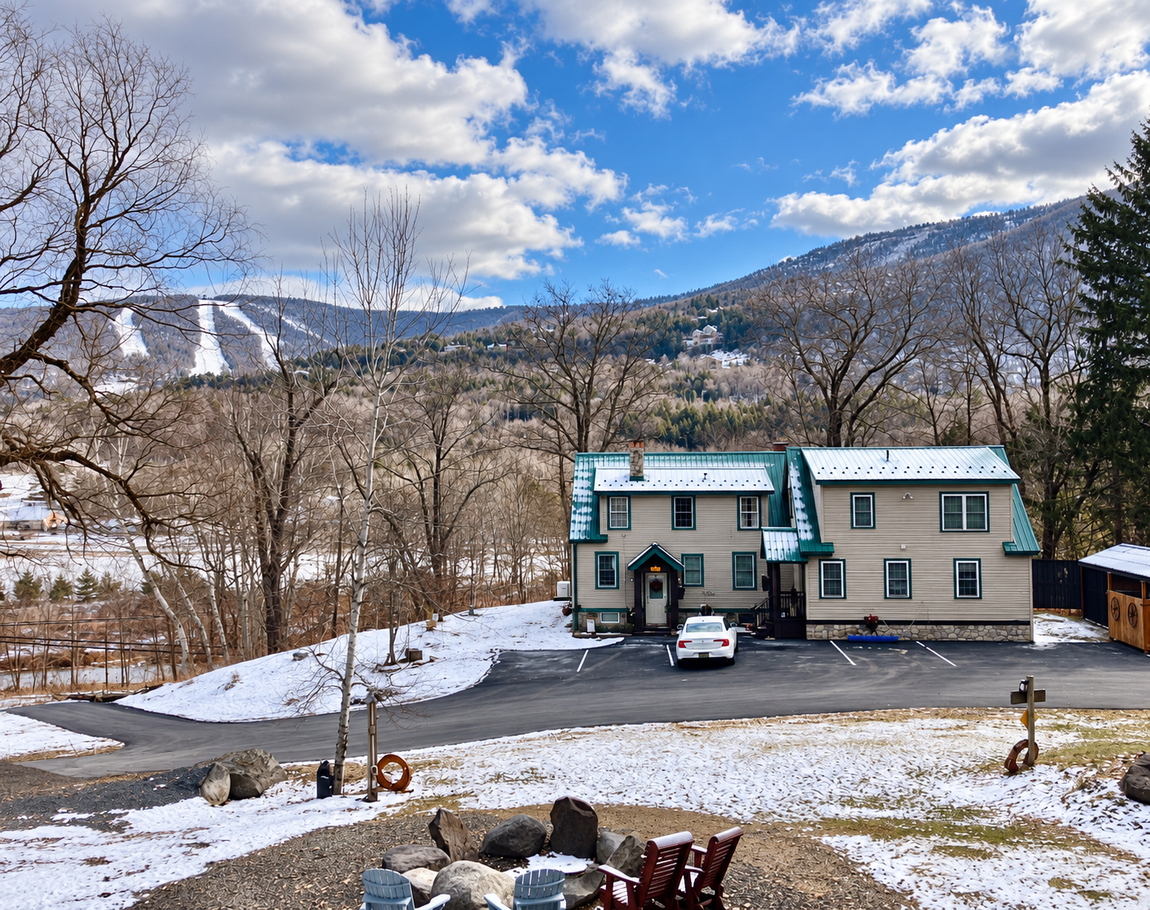 Winter view of Windham Vacation, with snow-covered grounds and Catskill Mountain ski slopes in the background.