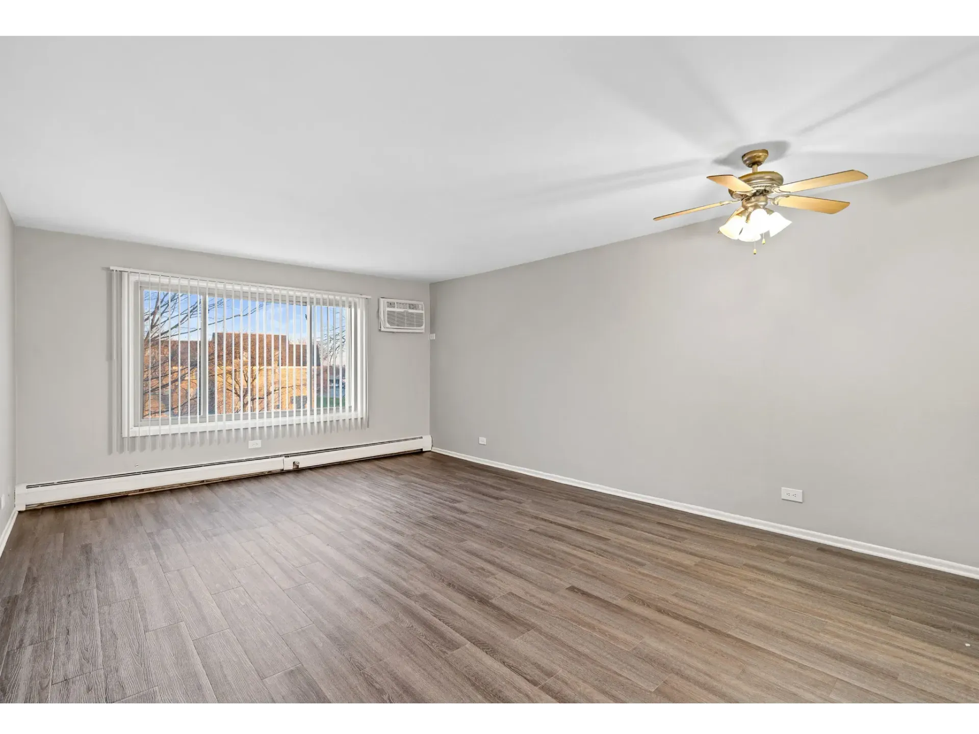 Spacious living room with large window and ceiling fan