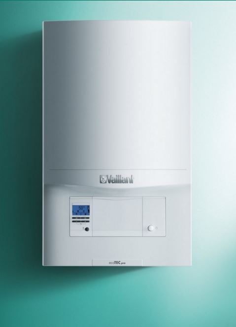 A white Vaillant wall-mounted gas boiler against a light green background.