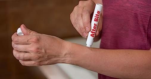 Person applying After Bite pen to their forearm.