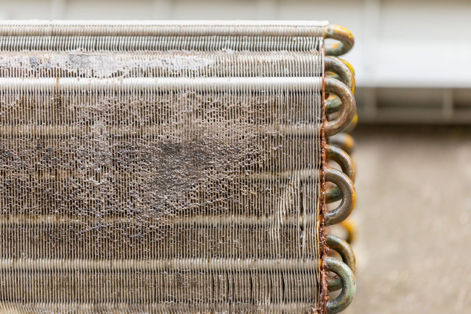 A close up of a dirty air conditioner coil.