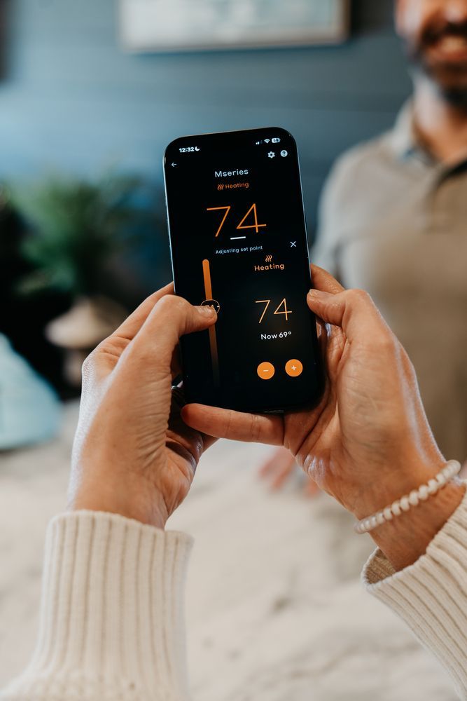 Hands holding a smartphone showing a dark orange fitness app interface in a blurred indoor setting