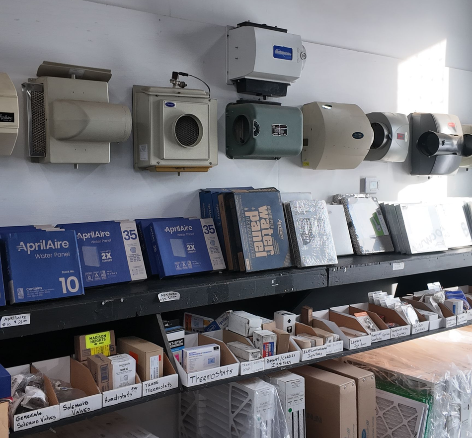 Shelves of packaged supplies and wall-mounted small appliances in a store aisle