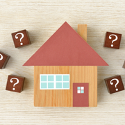 Toy house with question-mark blocks on a light wood background