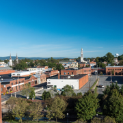 Panoramic view of a small brick downtown with church steeples under a clear blue sky