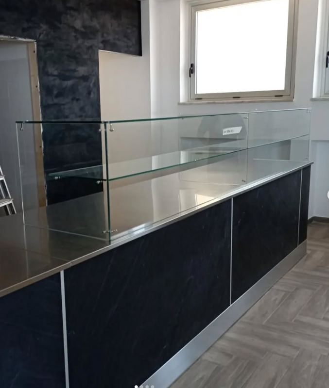 Vetrina da banco, pannello nero, finiture in acciaio inox, ripiani in vetro, sfondo per finestra.