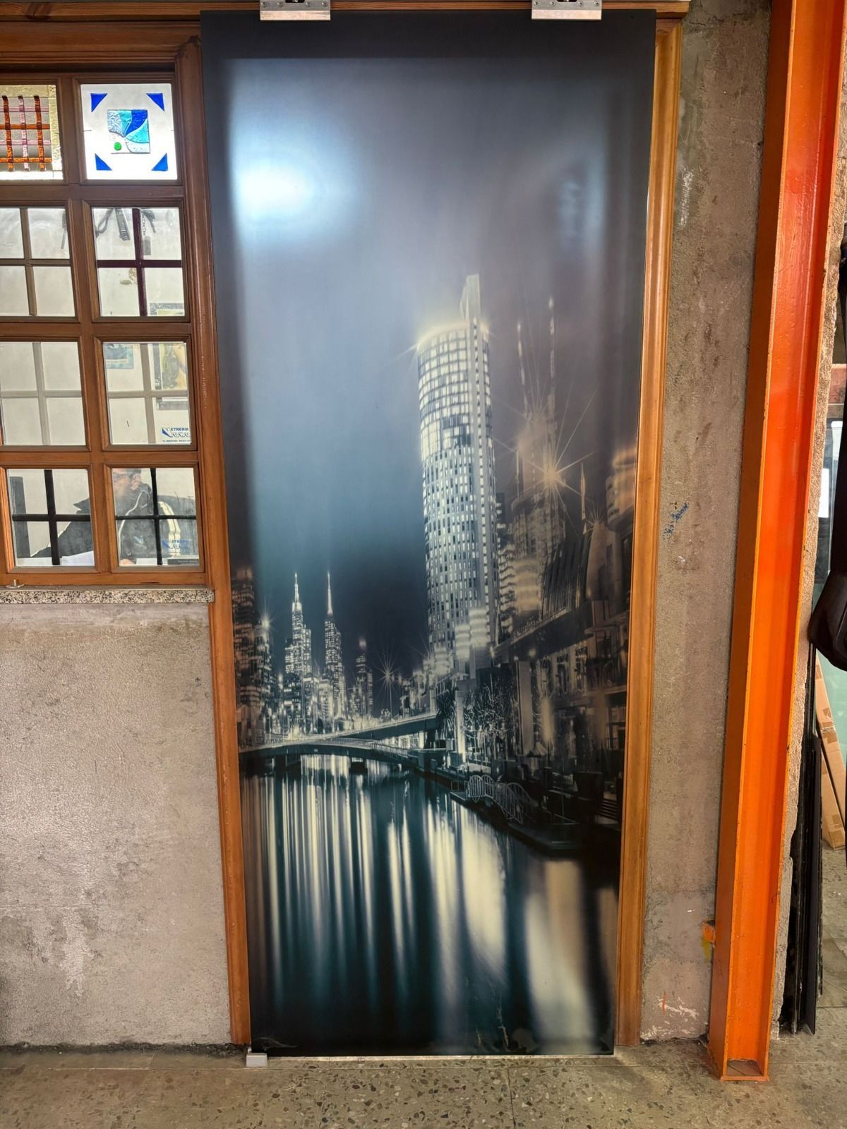 Porta con foto in bianco e nero di un paesaggio urbano riflesso nell'acqua.