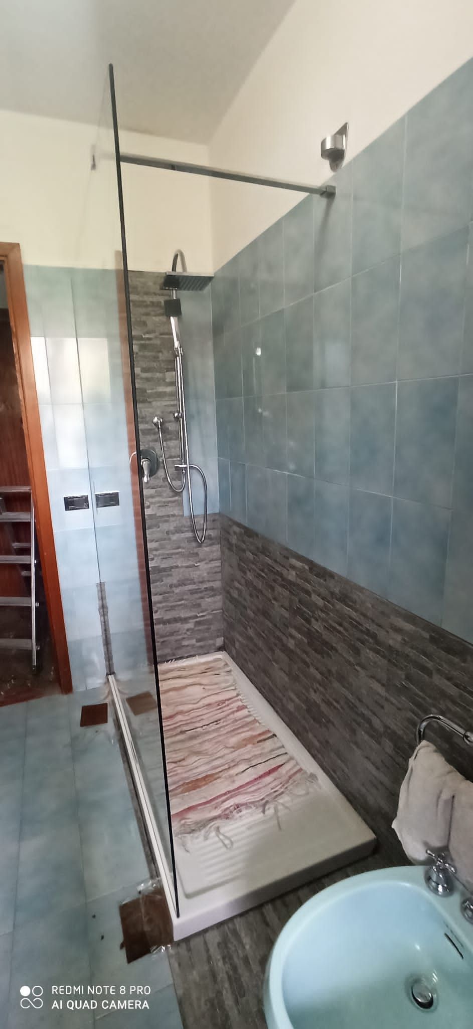 Doccia con pareti in vetro, getto d'acqua a cascata, pannello in vetro decorato.