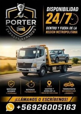 Una grúa remolcando levanta un coche negro, con trabajadores con chalecos naranjas junto a la carretera