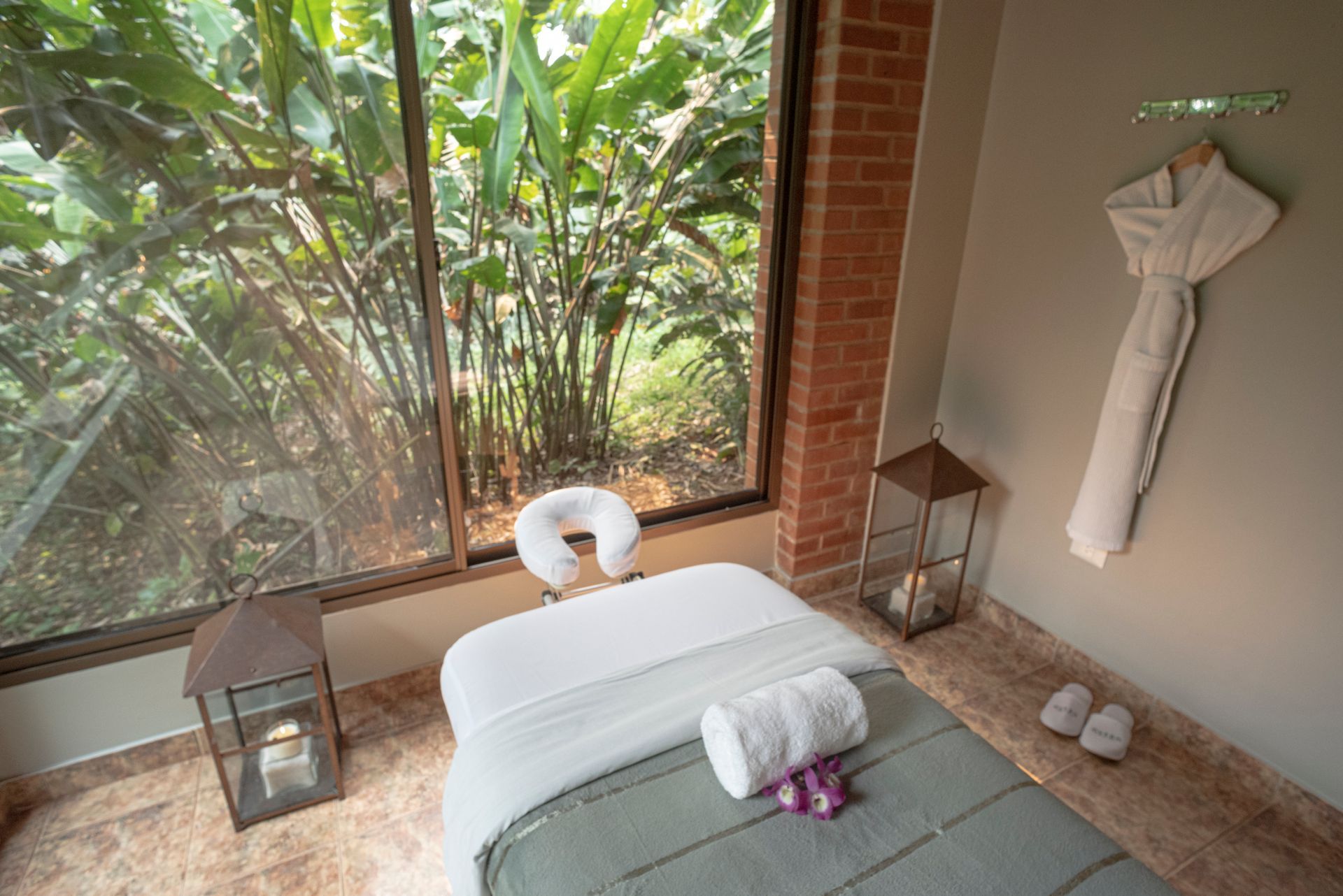 Espacio de bienestar con cama de masaje y ventanales que integran la selva, ambiente de relajación en el spa de Overo Iguazú.
