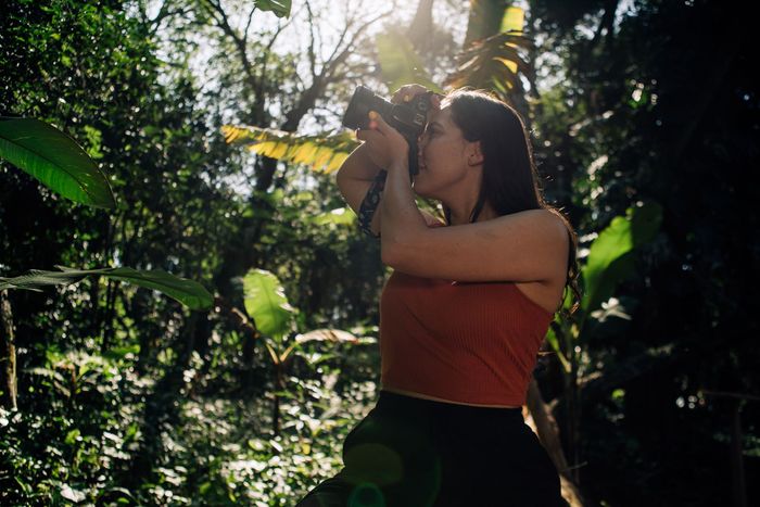 Mujer explorando la selva de Iguazú con la luz del sol filtrándose entre los árboles, conexión con la naturaleza en Overo.