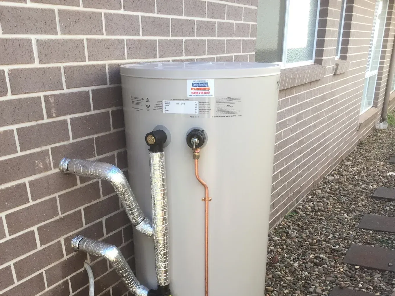 A person is measuring the temperature of a water heater