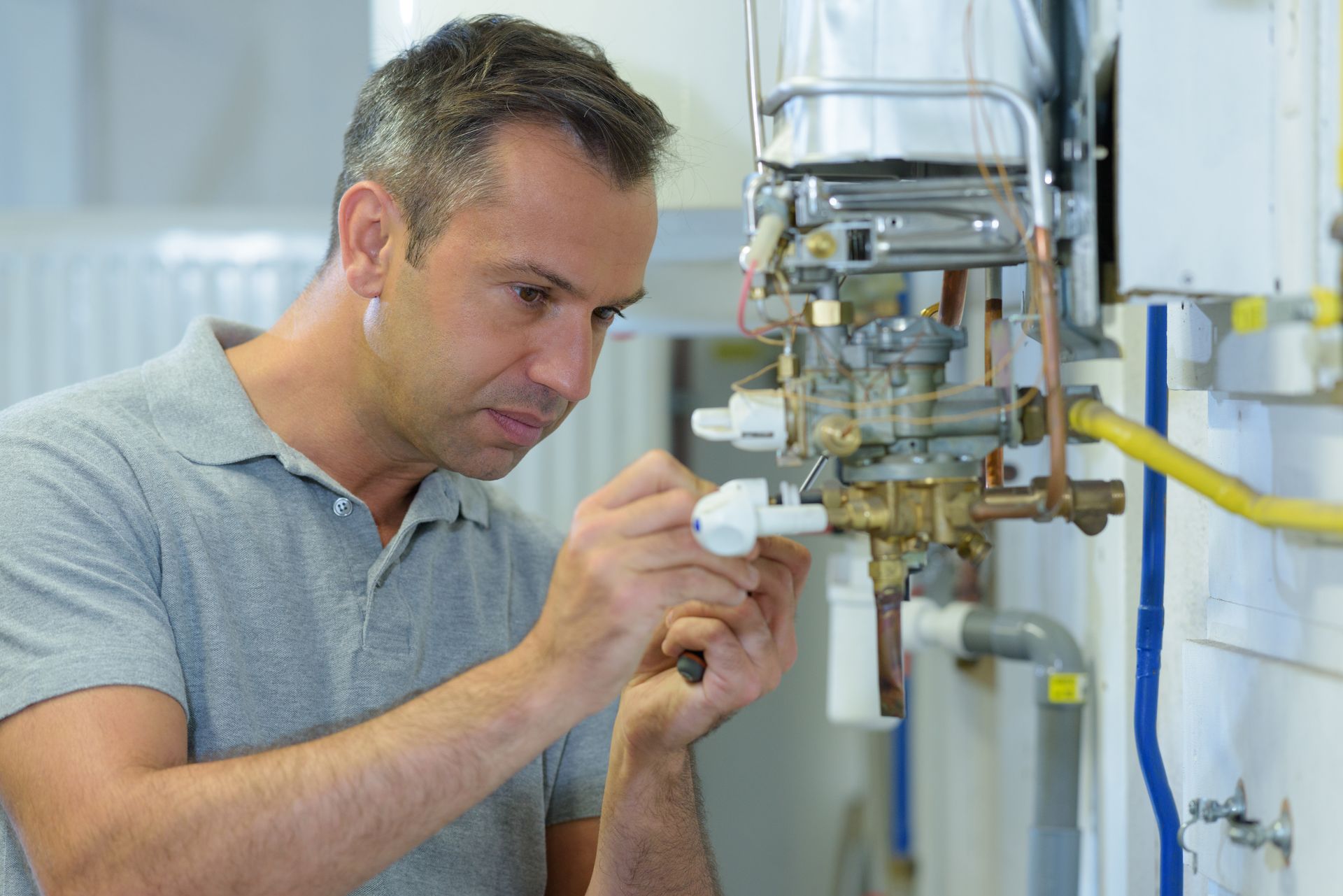 An engineer is checking on a gas boiler.