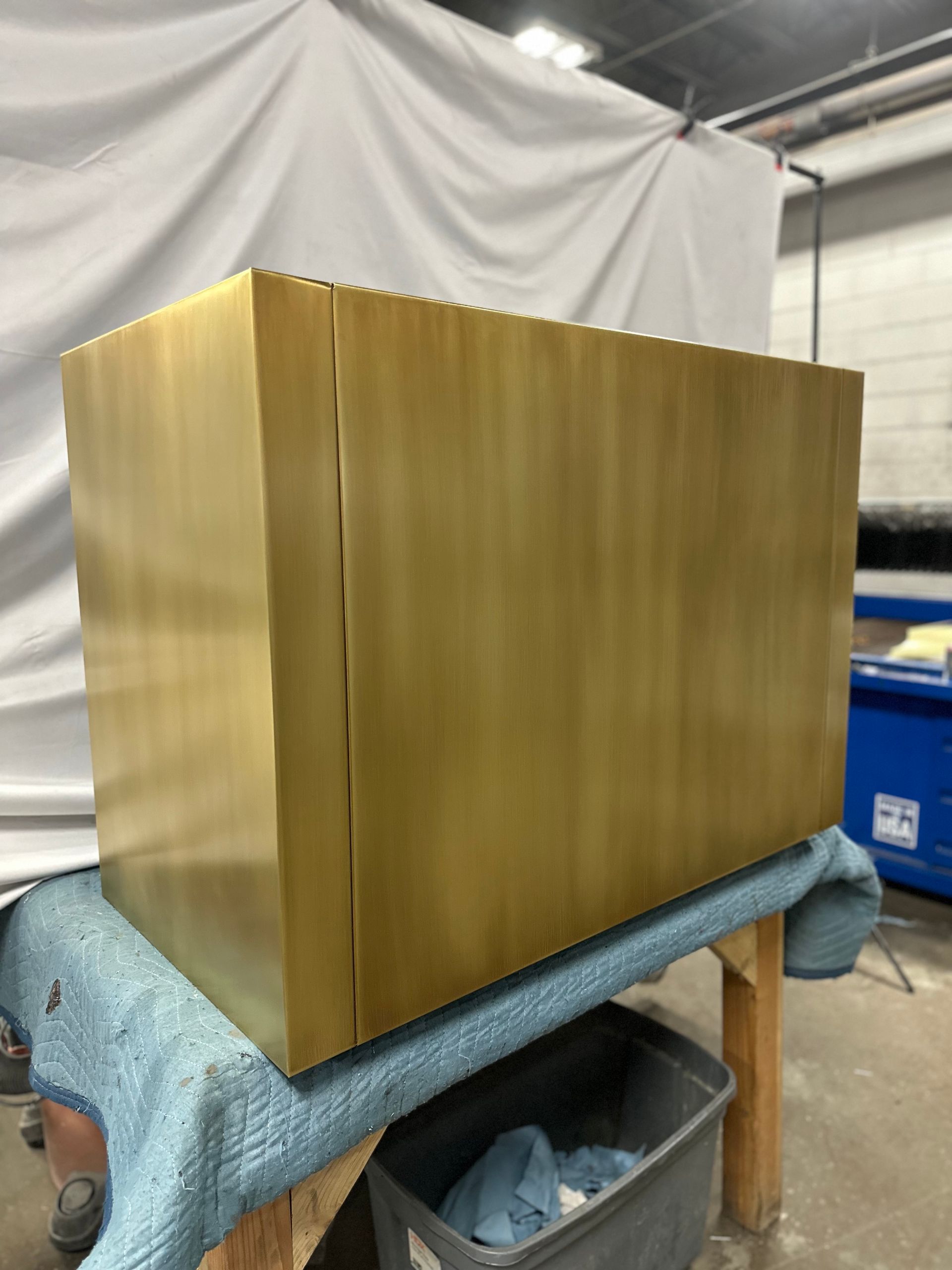 A brass box is sitting on a blue cloth on a table