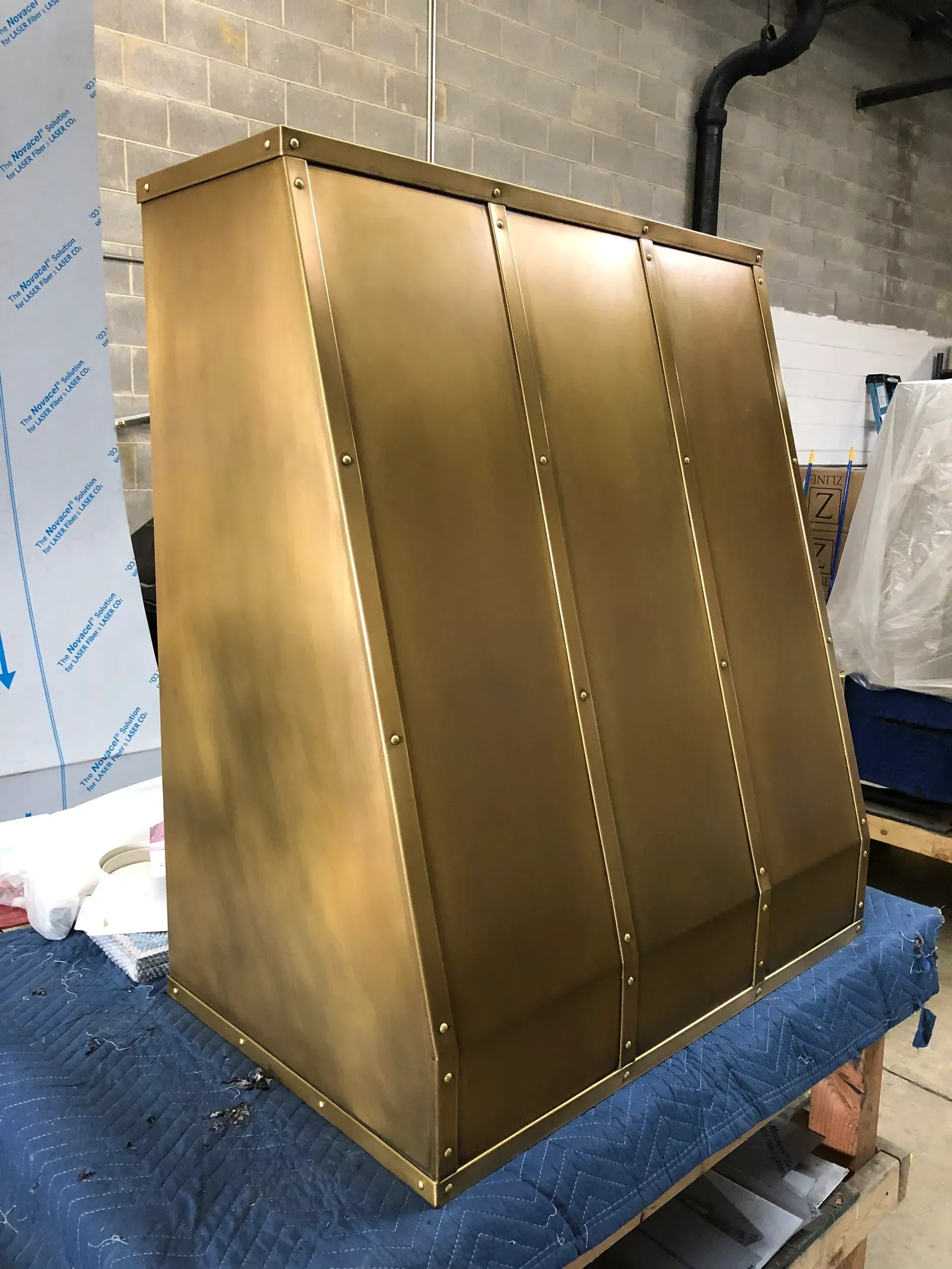 A brass cabinet is sitting on top of a wooden table.
