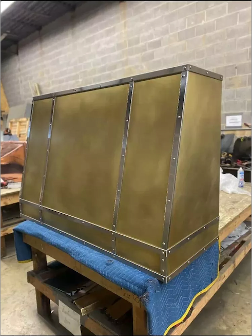 A large brass box is sitting on top of a wooden table.