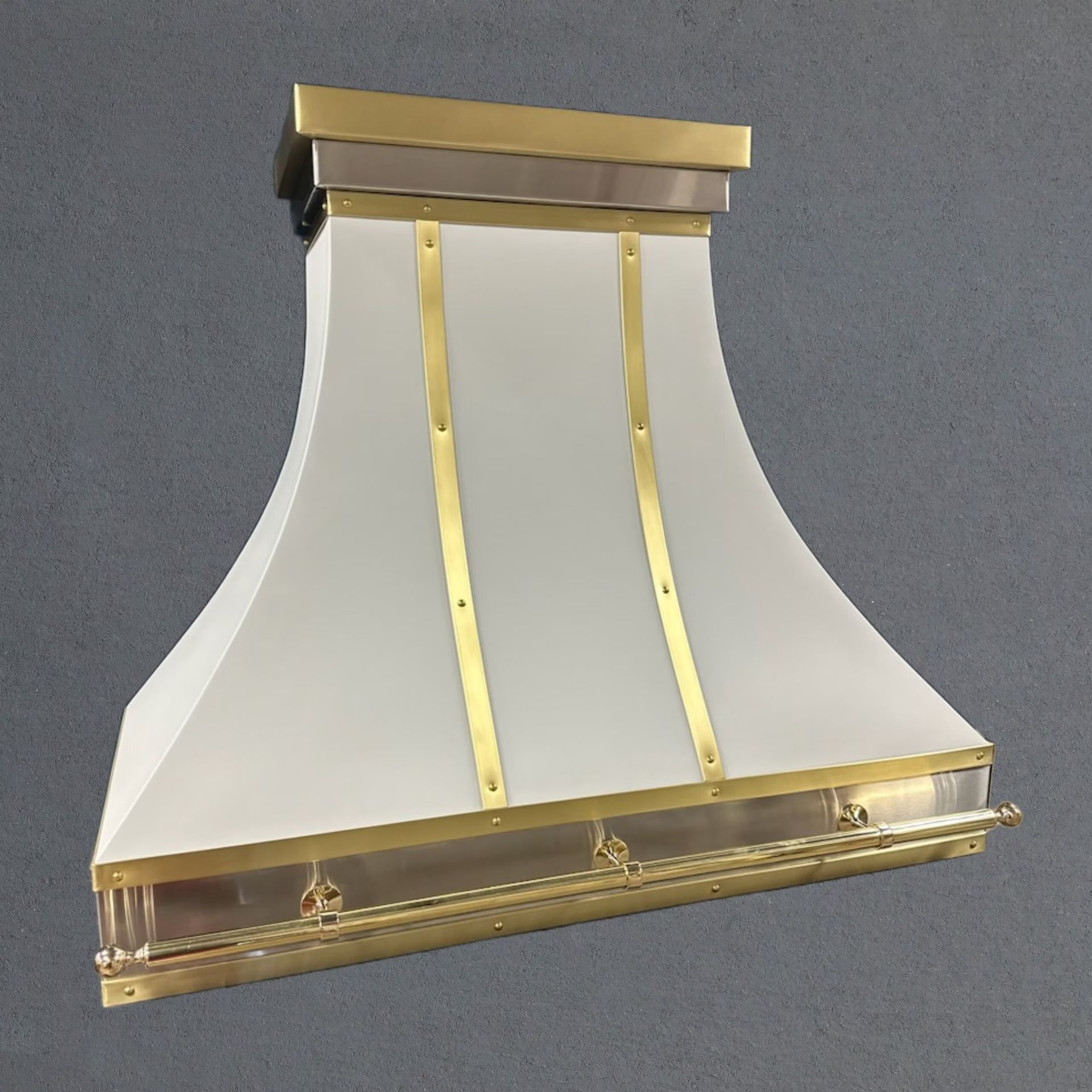 A white hood with brass trim is hanging from the ceiling