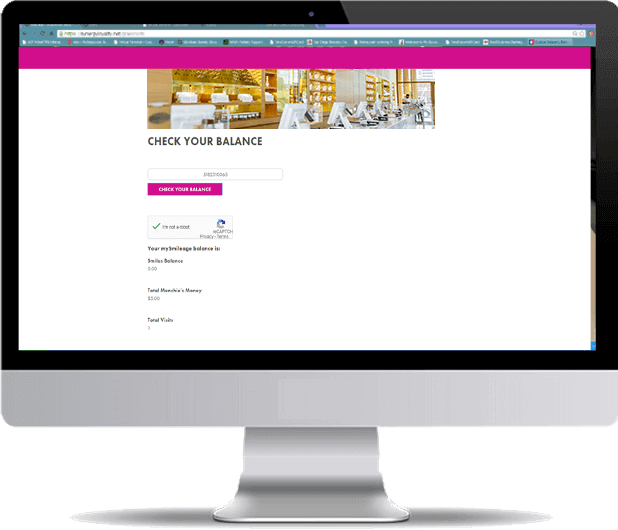 A computer monitor is open to a website that says check your balance