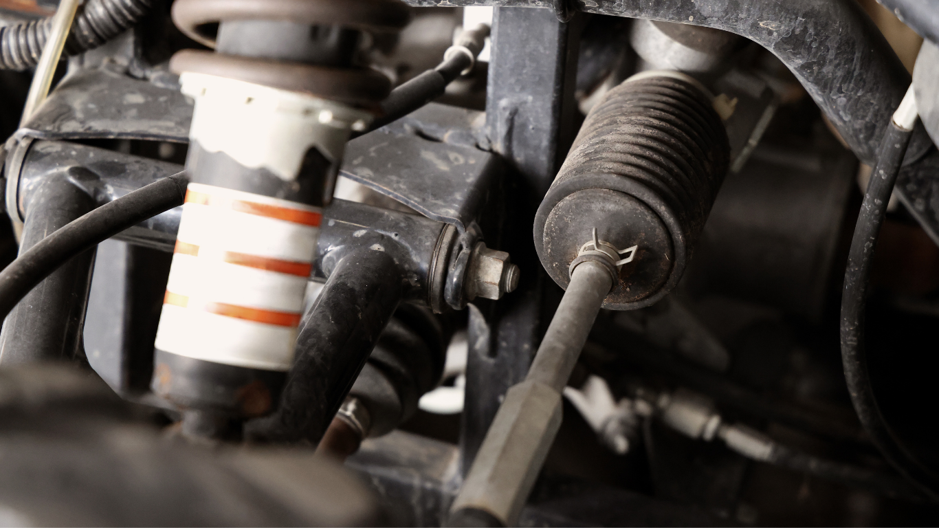 Close-up of a car engine with a spark plug and metal components.