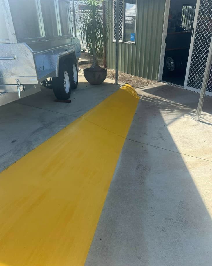 A Trailer Is Parked In A Parking Lot Next To A Yellow Curb — Wide Bay Line Marking in Wondunna, QLD