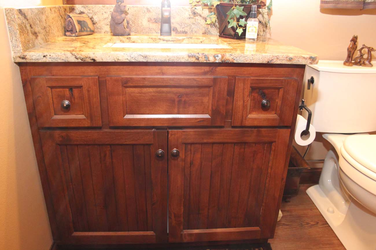 A bathroom with a wooden vanity and a toilet.