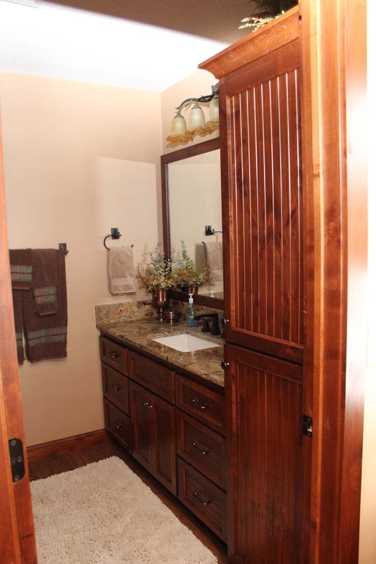 A bathroom with wooden cabinets and a sink