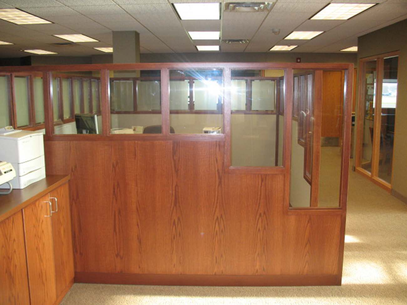 A cubicle in an office with a wooden divider