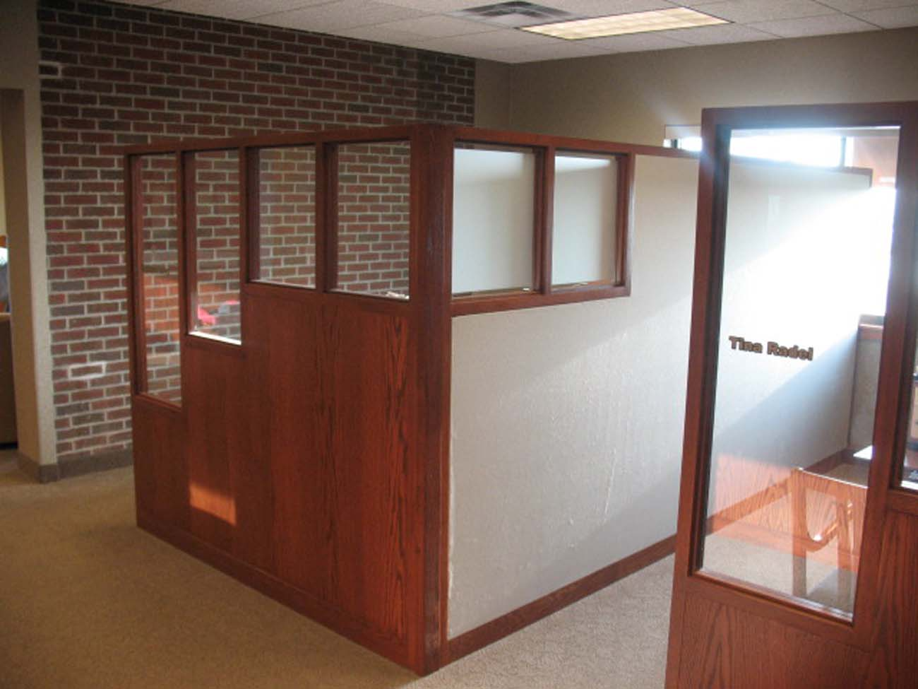 A cubicle in an office with a brick wall