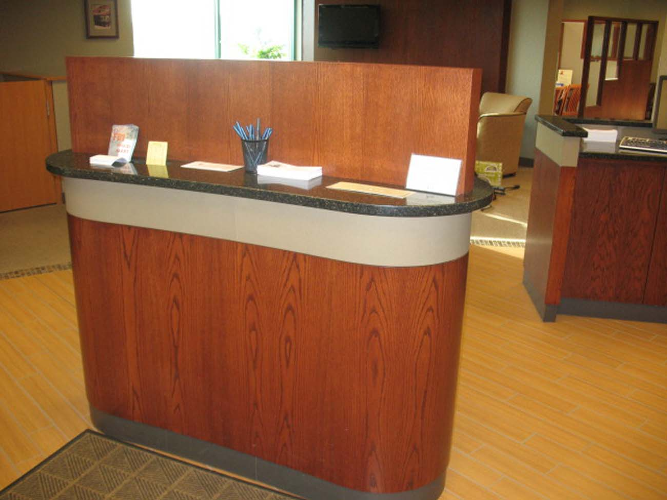 A wooden reception desk with a black counter top