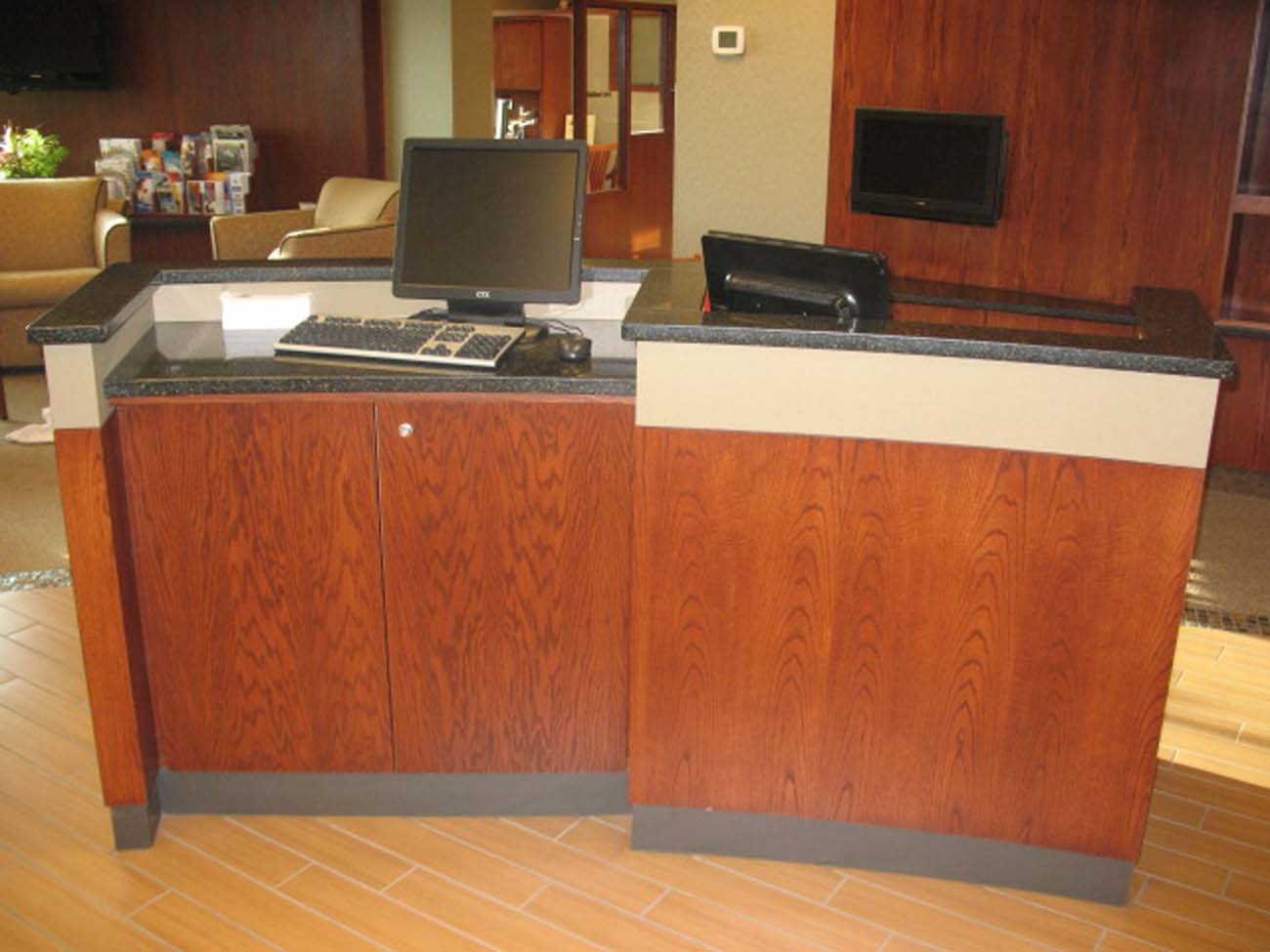 A wooden desk with a computer on top of it