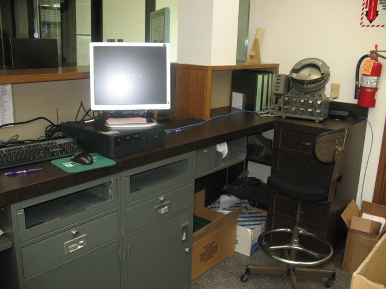 A desk with a computer and a fire extinguisher on it