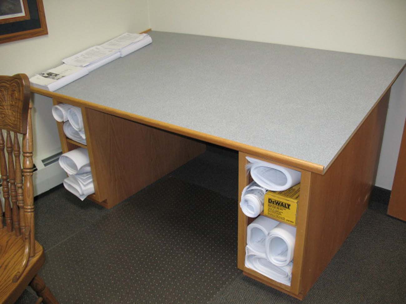 A desk with rolls of paper on it and a box that says dewalt on it