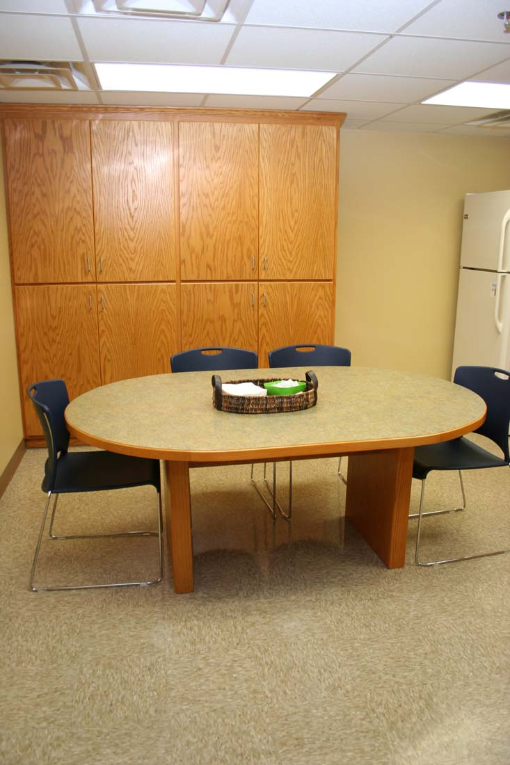 A room with a table and chairs and a refrigerator