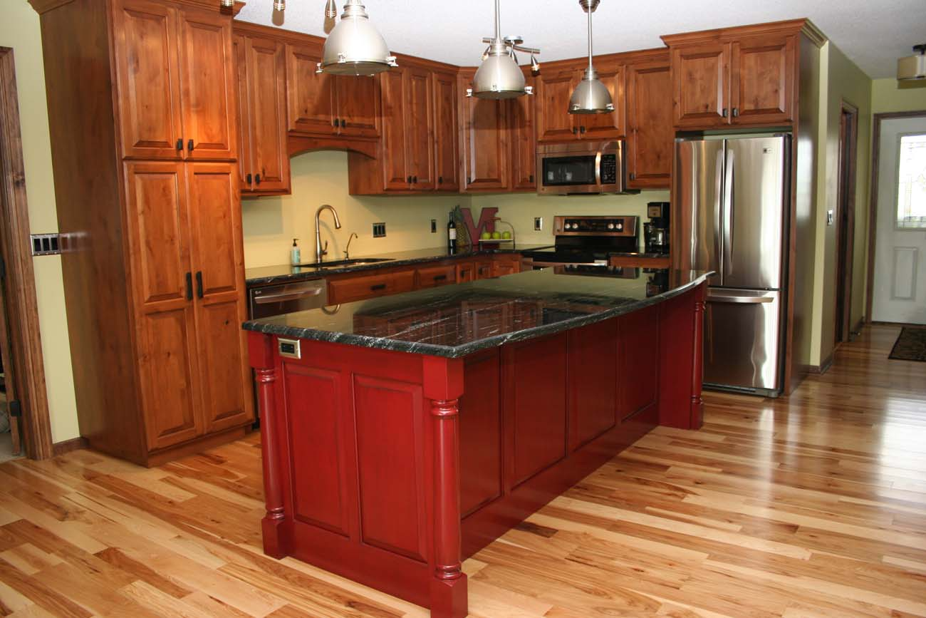 A kitchen with a large red island in the middle