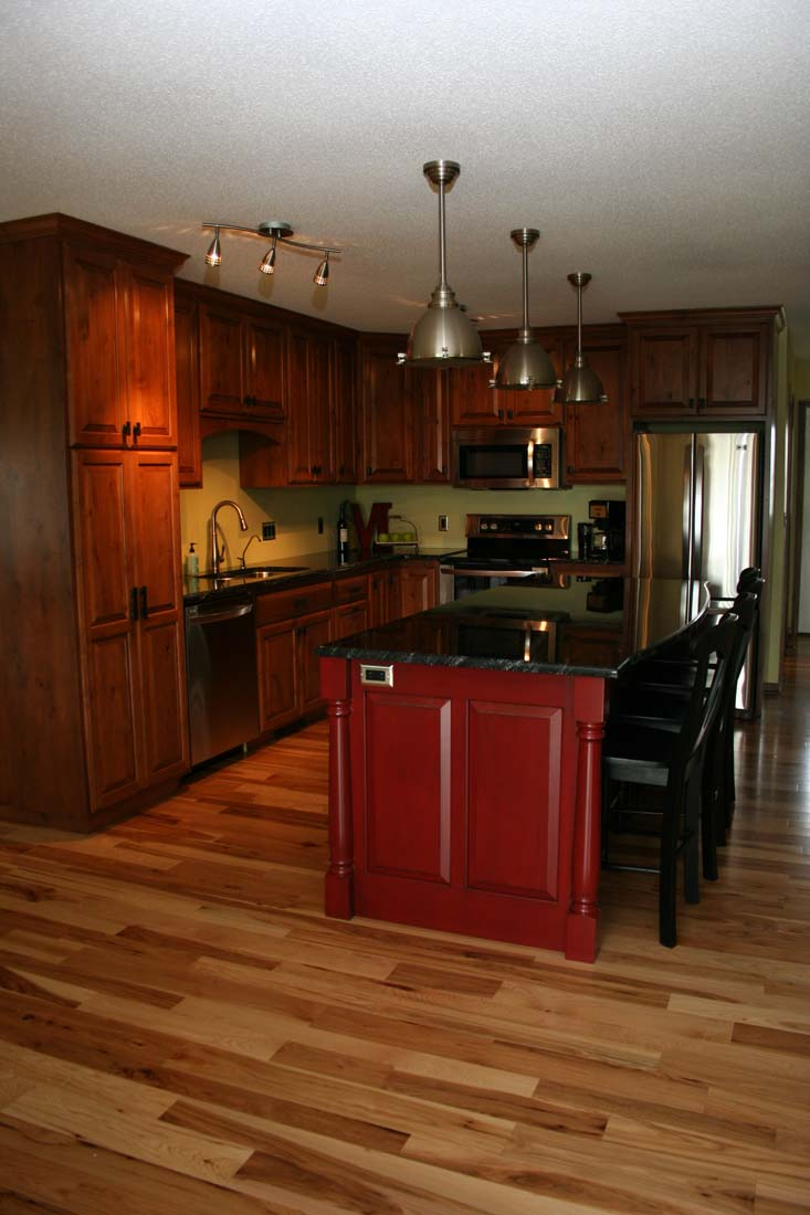 A kitchen with a large red island in the middle