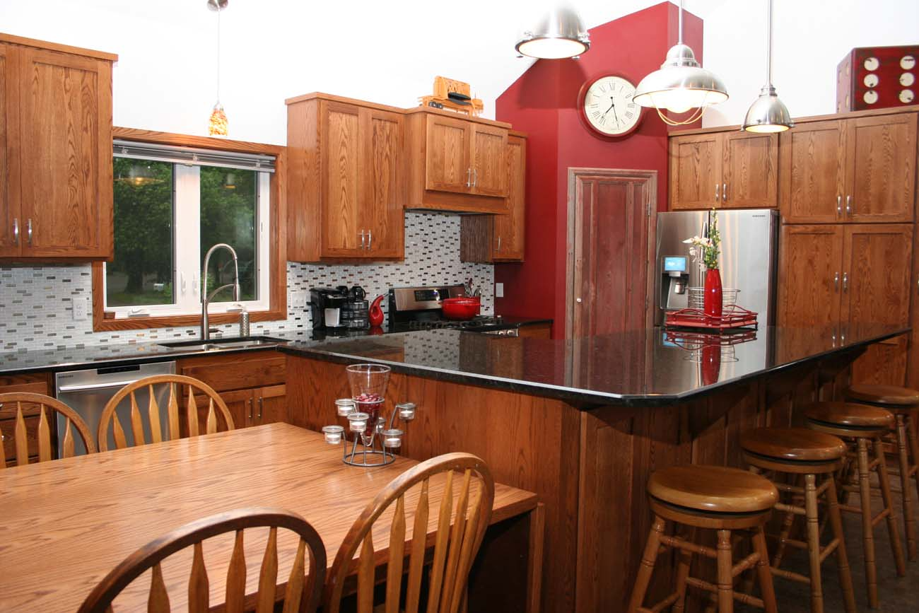 A kitchen with a table and chairs and a clock on the wall