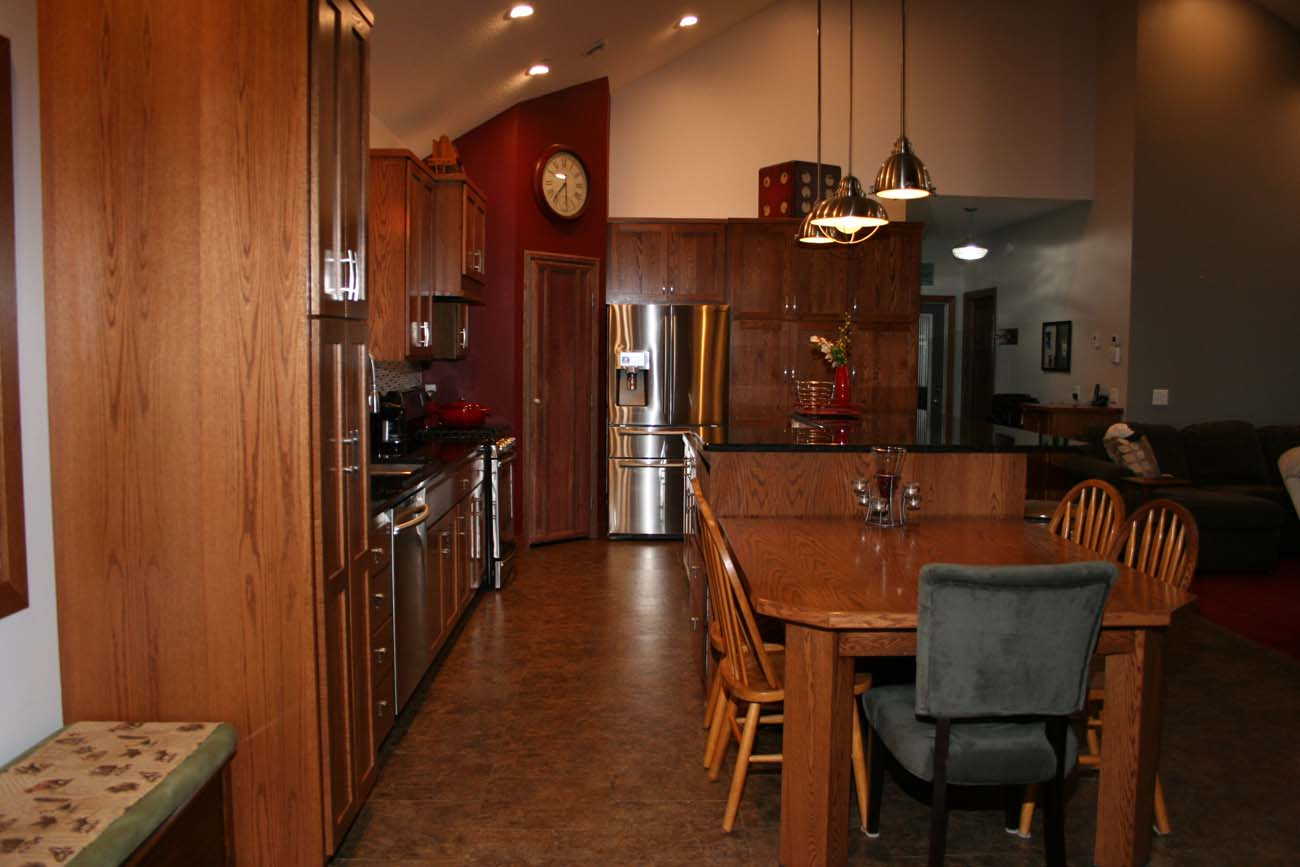 A kitchen with a table and chairs and a clock on the wall