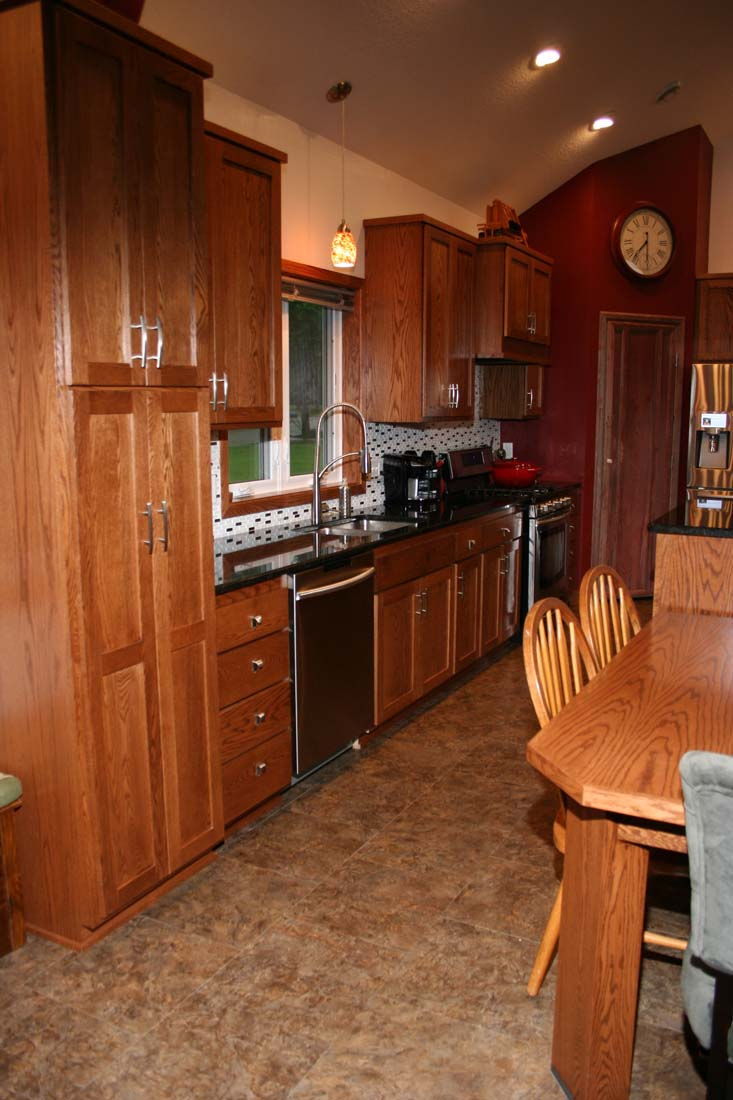 A kitchen with wooden cabinets and a table and chairs